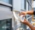 Construction workers apply foam tape for signage mounting, panel positioning, trim fixing and light sealing on building surfaces, mounting